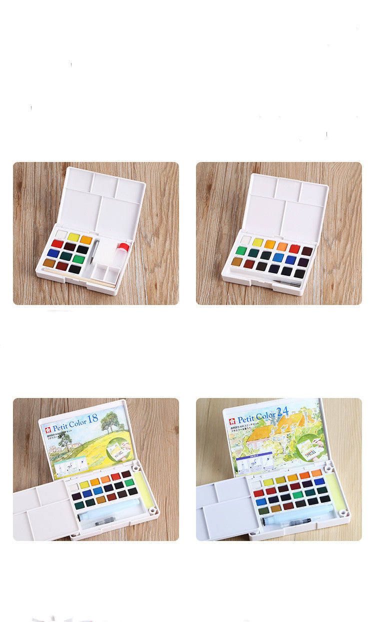 Set of watercolor paint boxes on a wooden surface