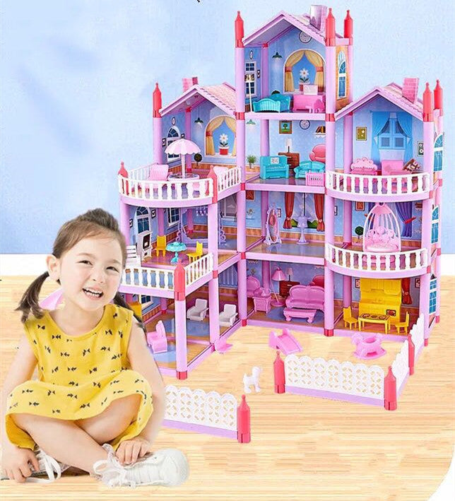 Child with a large, multi-story dollhouse with detailed furniture on a wooden floor.
