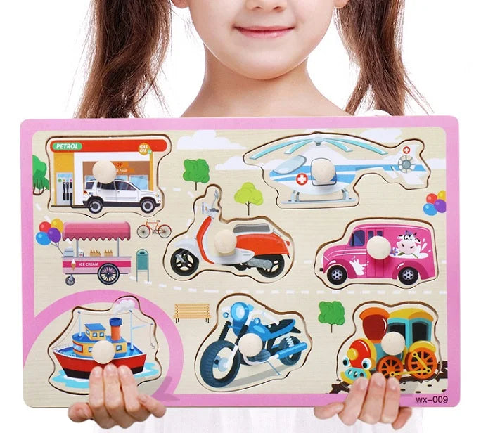 Child holding a wooden puzzle with various vehicles and scenes