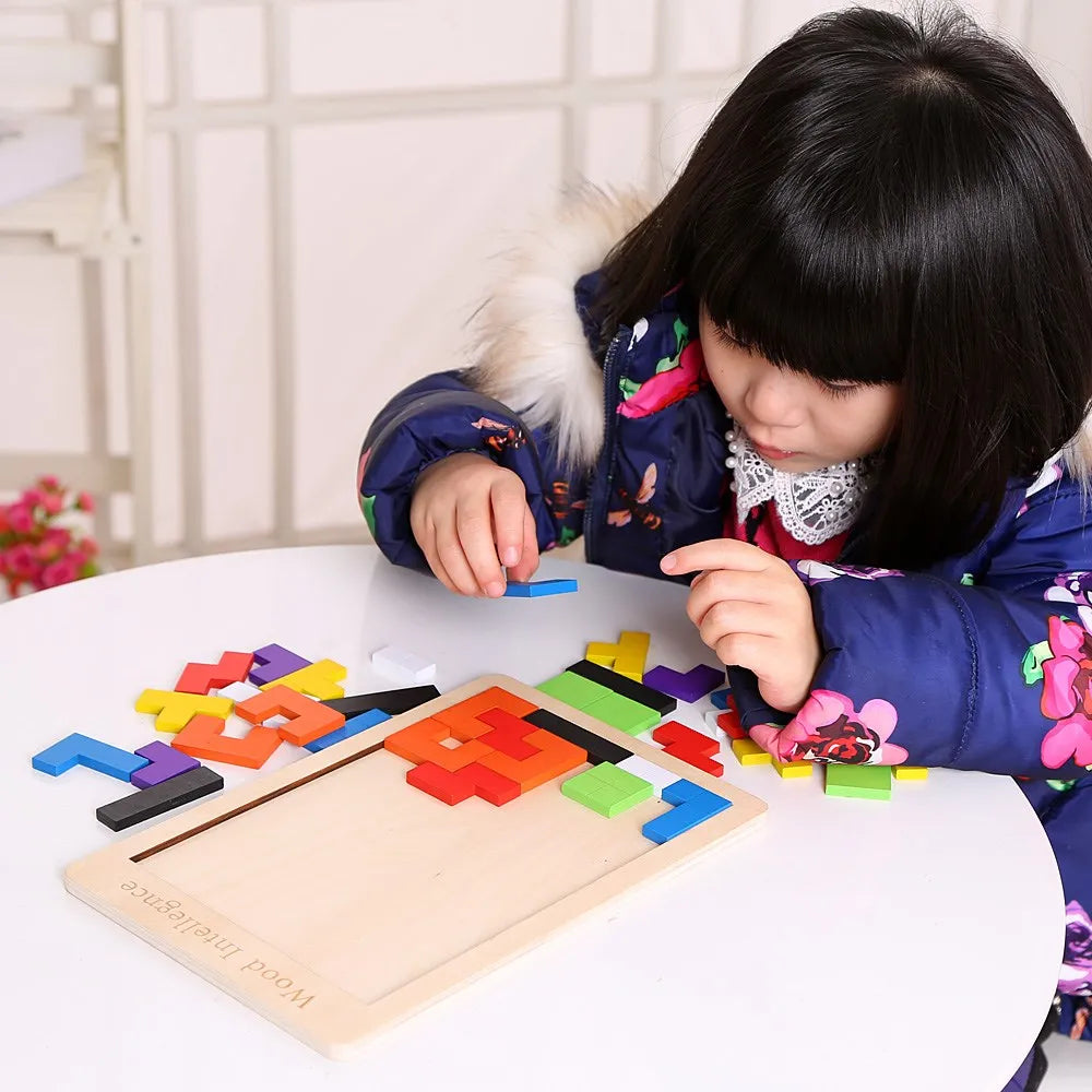 Child playing with colorful wooden puzzle on a table