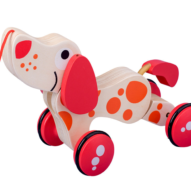 Wooden toy dog with red wheels and spots on a white background