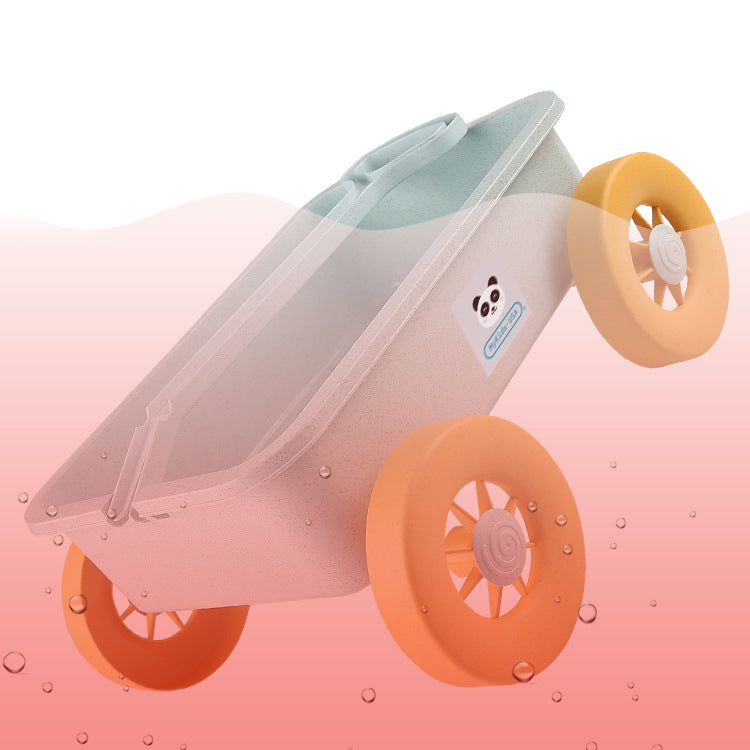 Toy wheelbarrow with orange wheels on a pink background