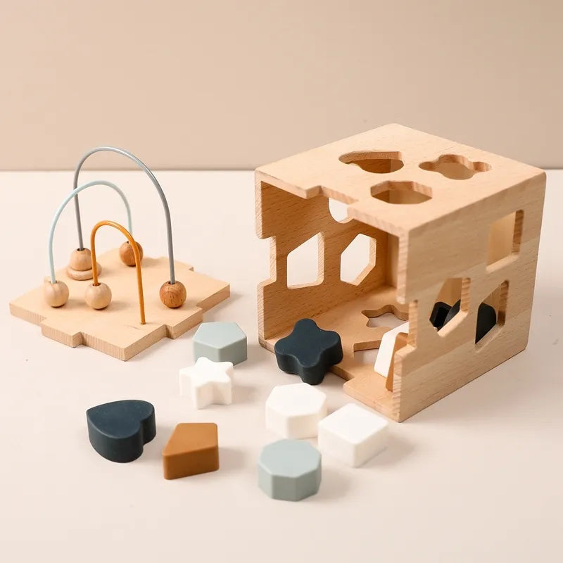 Wooden shape sorting toy set with beads and various wooden shapes on a beige background