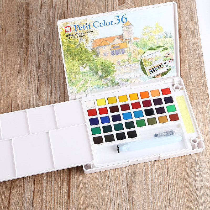 Watercolor set with color swatches on a wooden surface