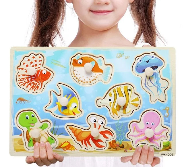 Child holding a wooden puzzle with sea creature illustrations