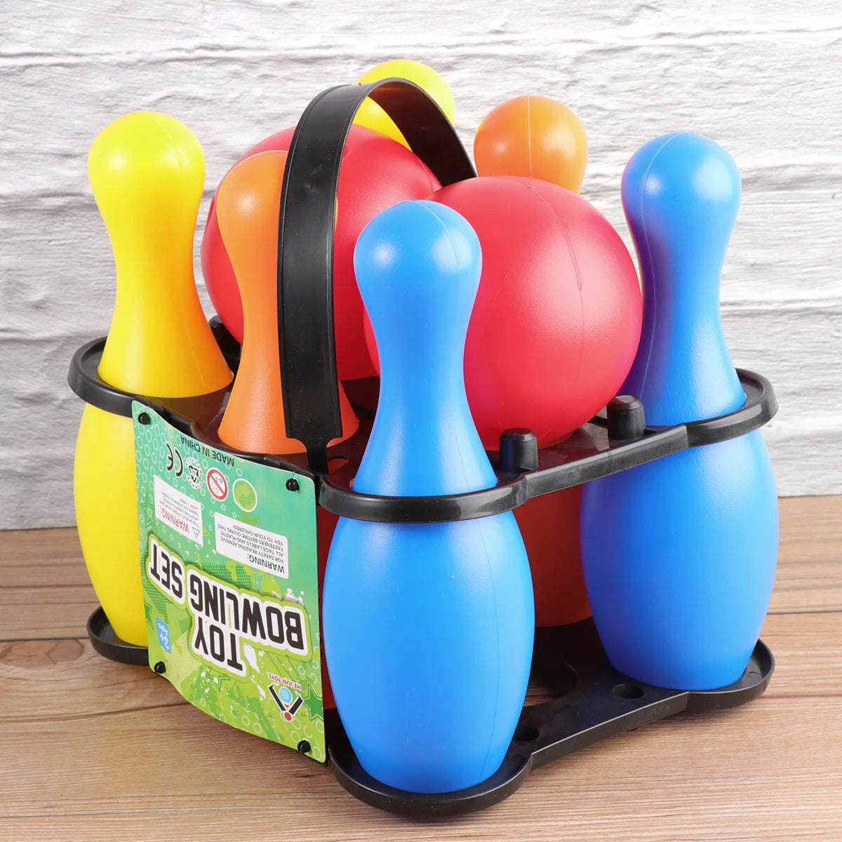 Colorful toy bowling pins set in a carrying tray on a wooden surface.