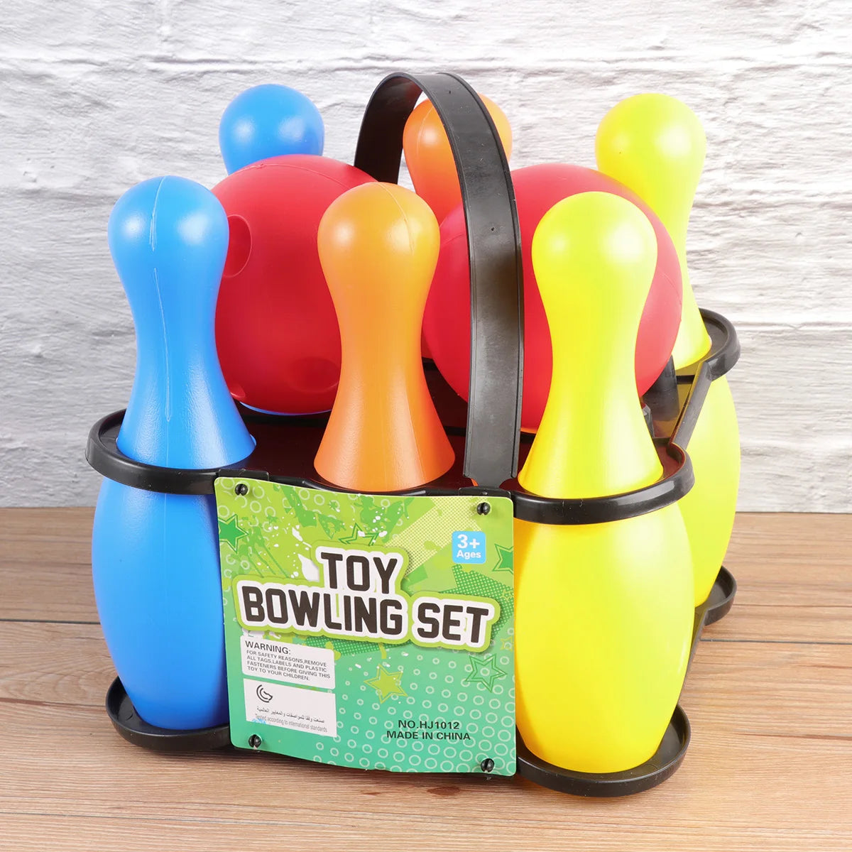 Colorful toy bowling set with pins and a carrying case on a wooden surface.