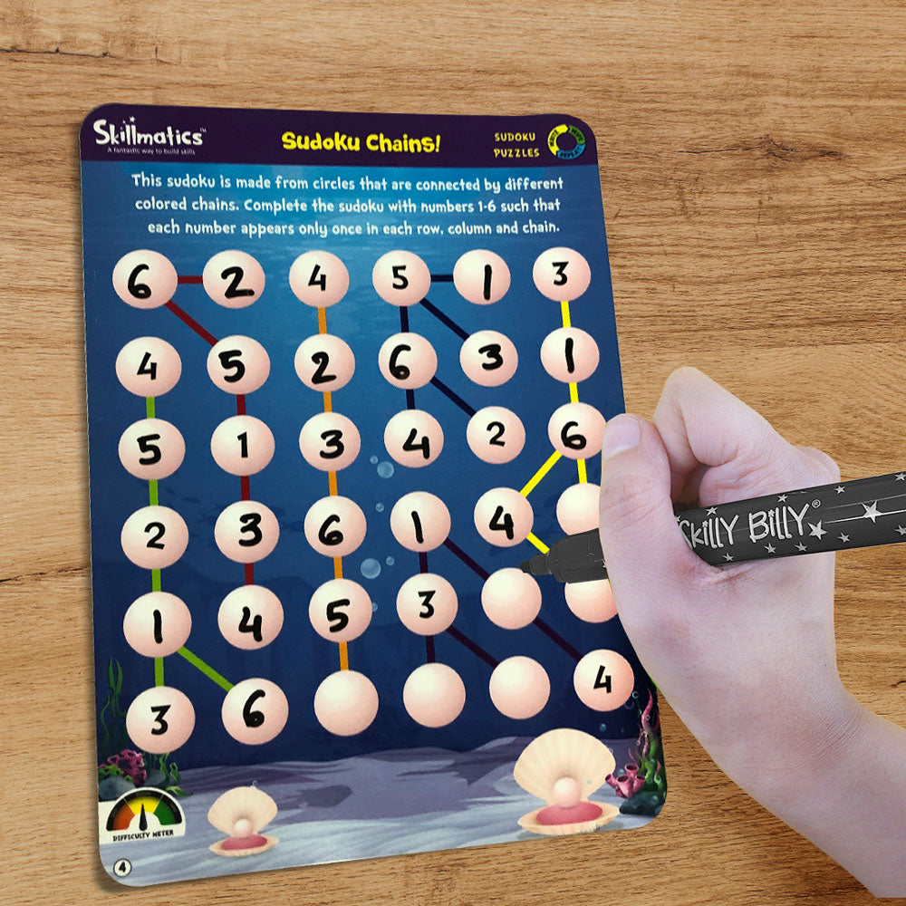 Sudoku puzzle with a hand using a pen to solve it on a wooden surface