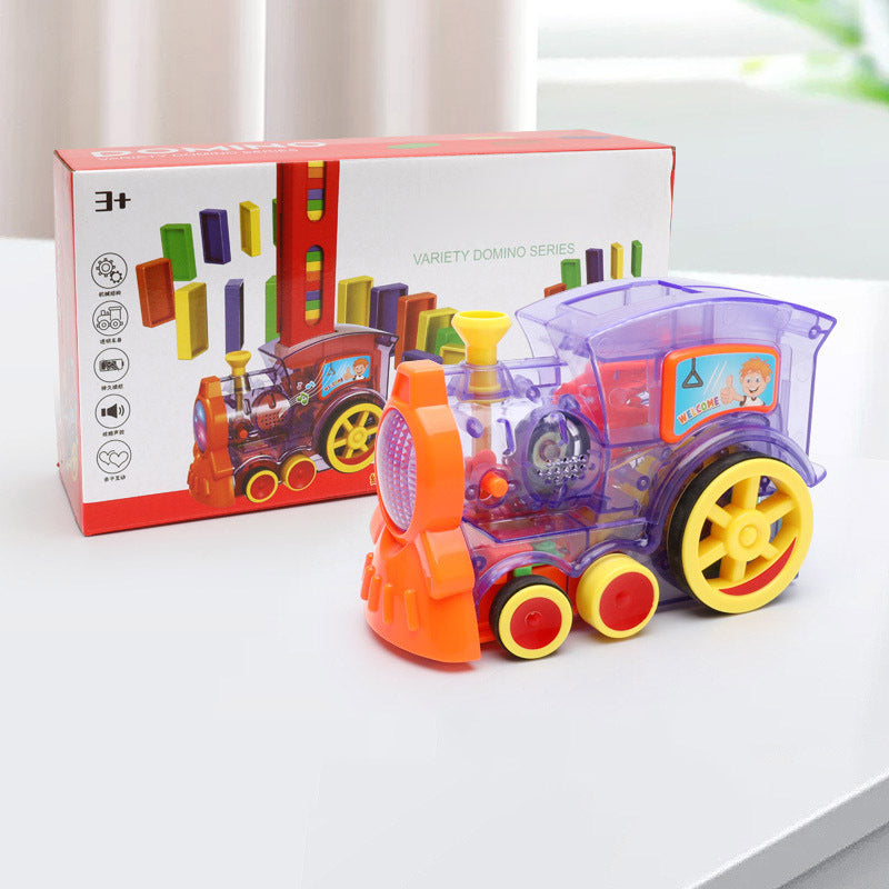 Colorful toy train with transparent car and orange front section, next to its packaging on a light surface.