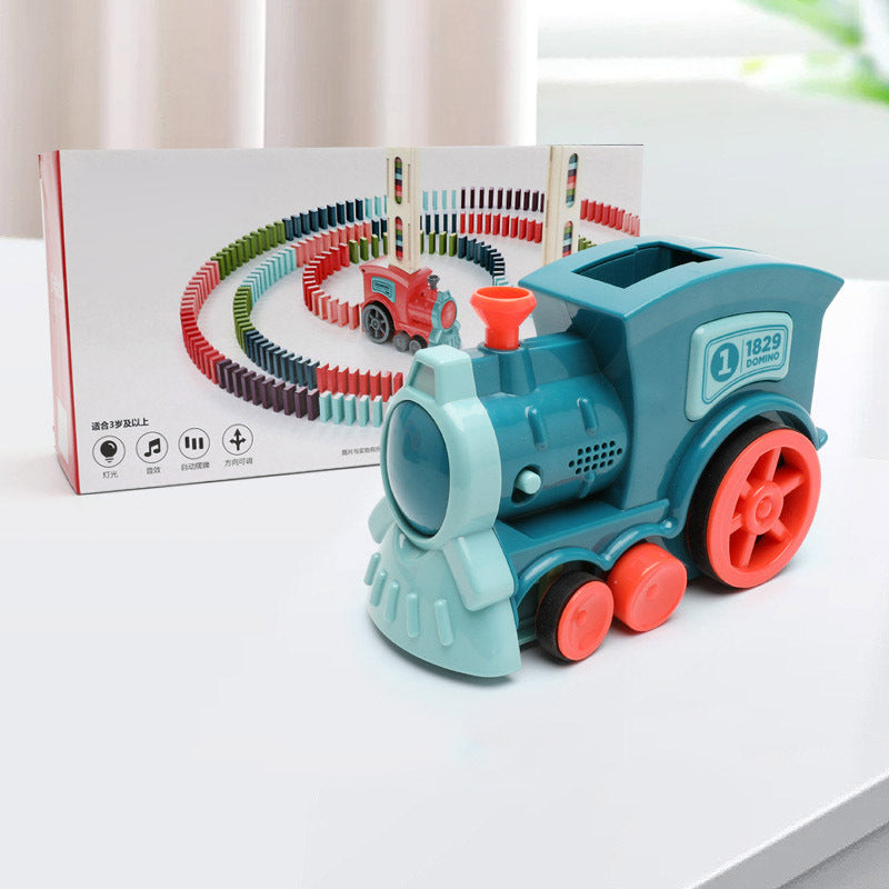 Toy train with a box of track pieces on a white surface