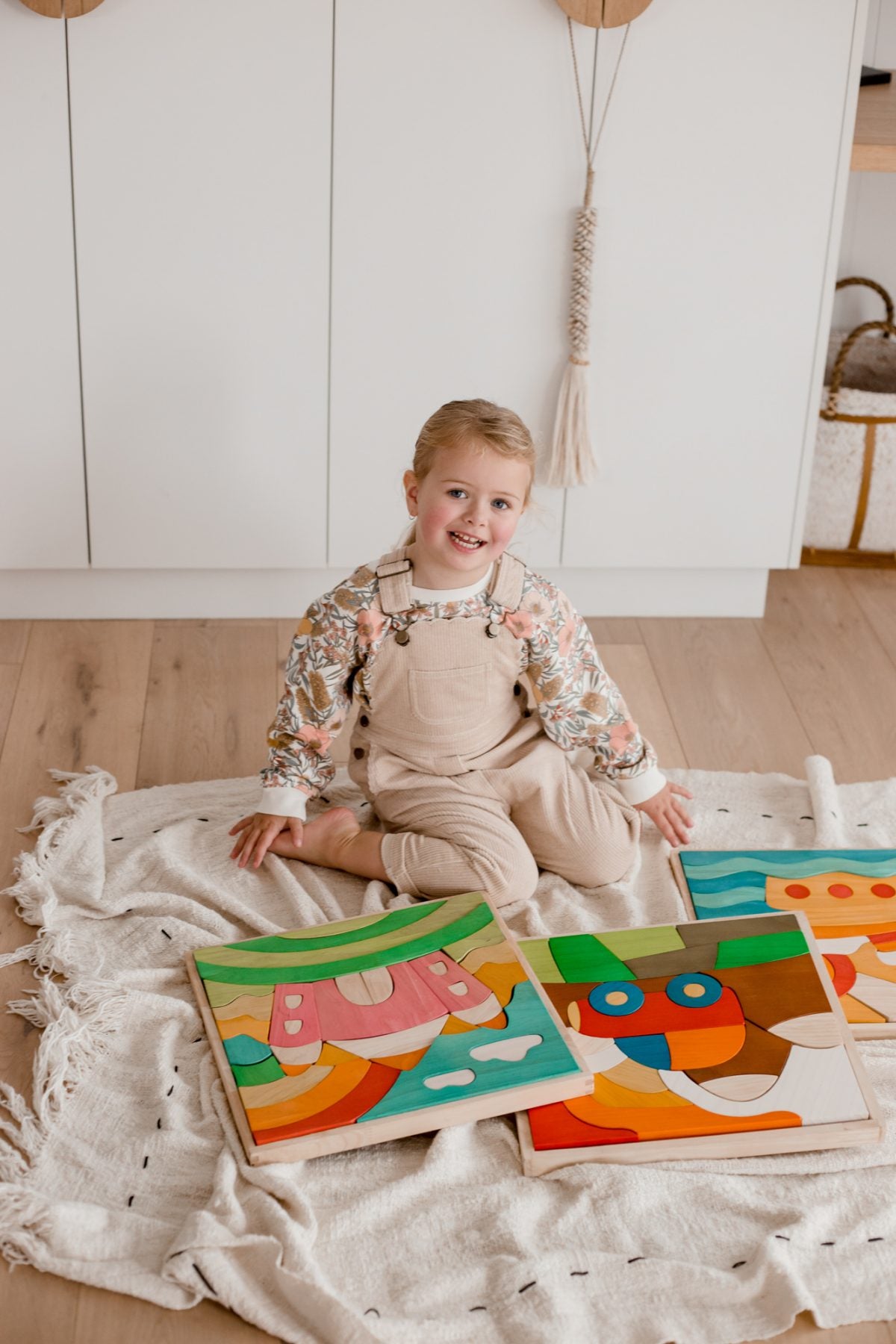 Child playing with colorful wooden puzzles on a white rug