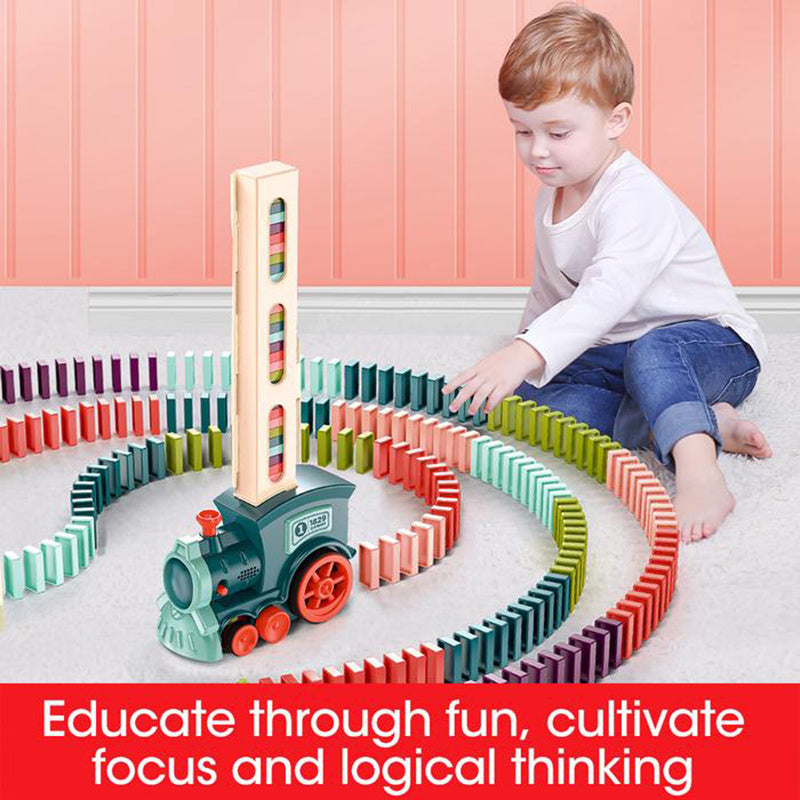 Child playing with a colorful wooden domino train set on a pink floor.
